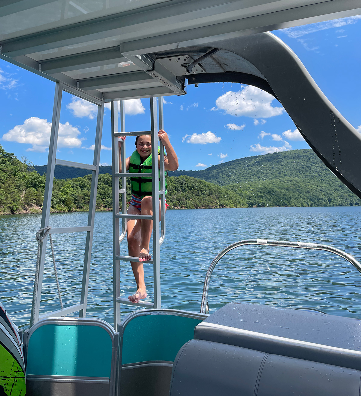 Little girl climbing the ladder to the slide on pontoon boat on Raystown Lake, PA