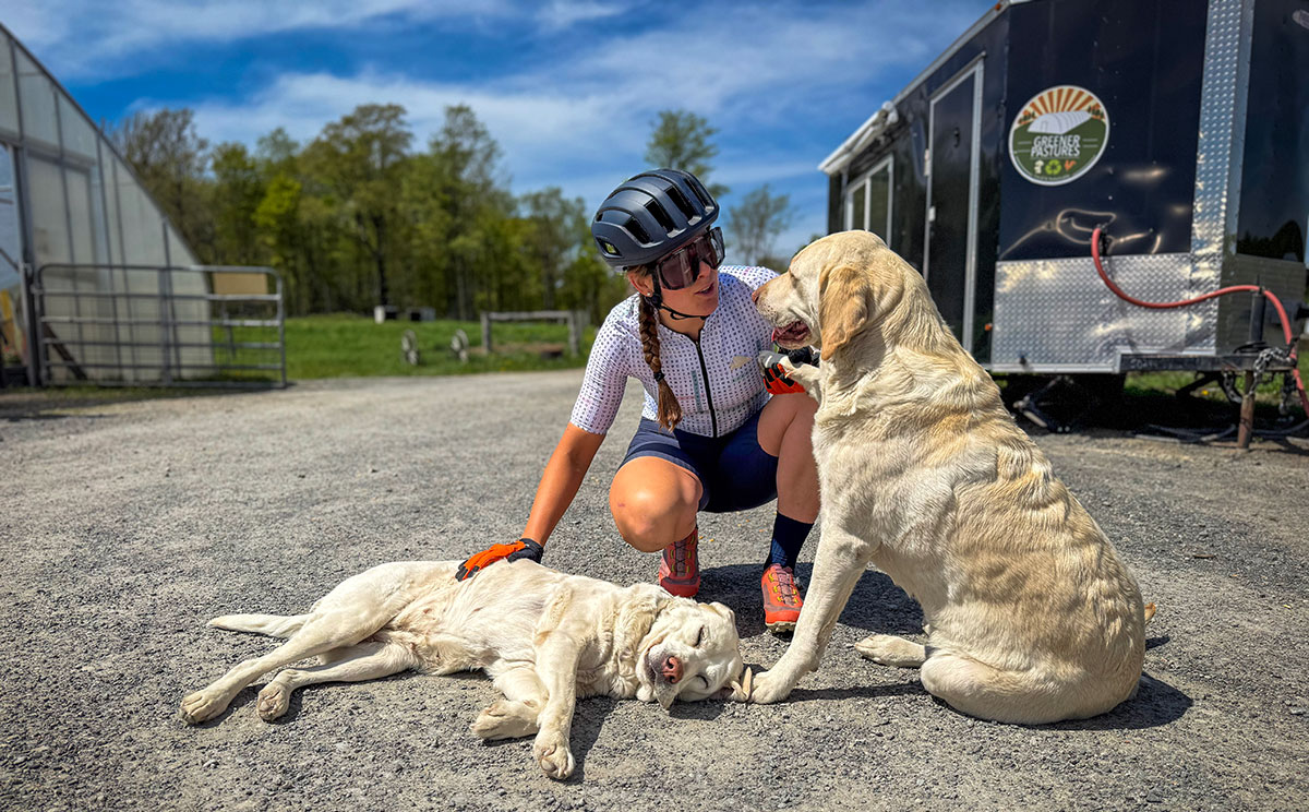 Cyclist petting dogs along the Endless Mountains Grave Cycling Path